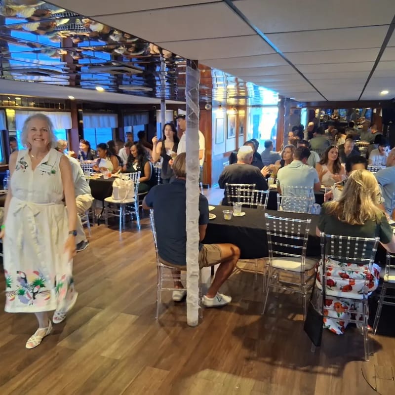Guests seated at tables in the yacht's dining room