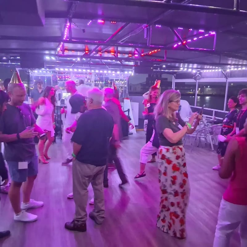 Guests dancing under pink and purple lights on the yacht