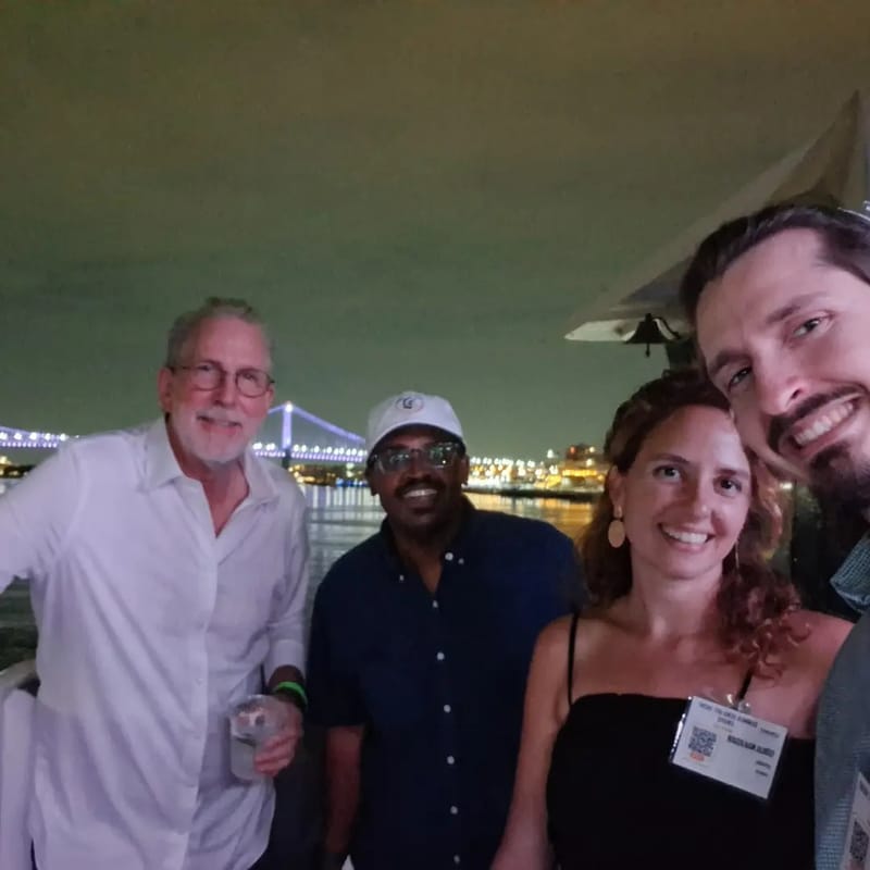Chris Gittings taking a selfie with three guests on the deck at night